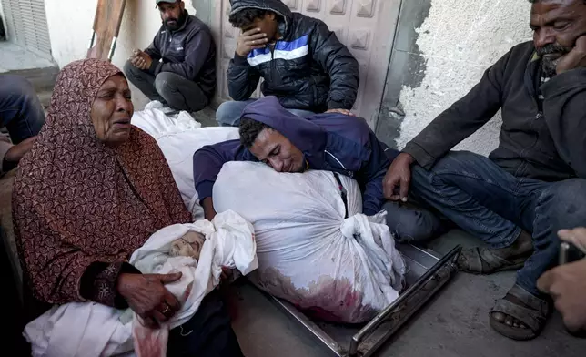 EDS NOTE: GRAPHIC CONTENT - Palestinians mourn their relatives killed in the Israeli bombardment of the Gaza Strip at a hospital morgue in Deir al-Balah, Friday, Nov. 1, 2024. (AP Photo/Abdel Kareem Hana)