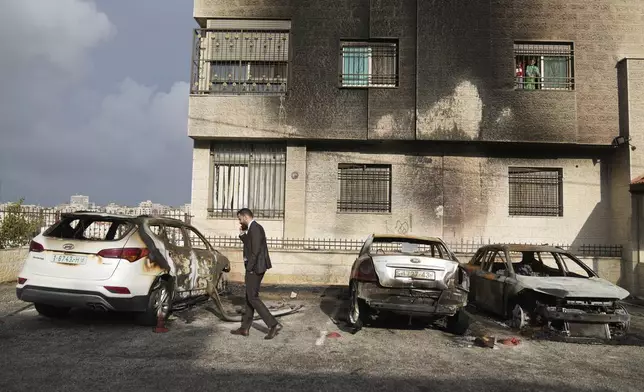 Palestinians inspect vehicles that were burnt during an early morning attack by Israeli settlers, that left at least 18 burnt vehicles, on the outskirts of the West Bank city of al-Bireh Monday, Nov. 4, 2024. (AP Photo/Nasser Nasser)