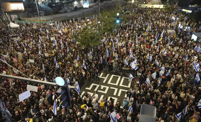 People march in a protest in Tel Aviv, Israel, Saturday, Nov. 9, 2024 against Prime Minister Benjamin Netanyahu's government and call for the release of hostages held in the Gaza Strip by the Hamas militant group, marking 400 days since their capture. (AP Photo/Ohad Zwigenberg)