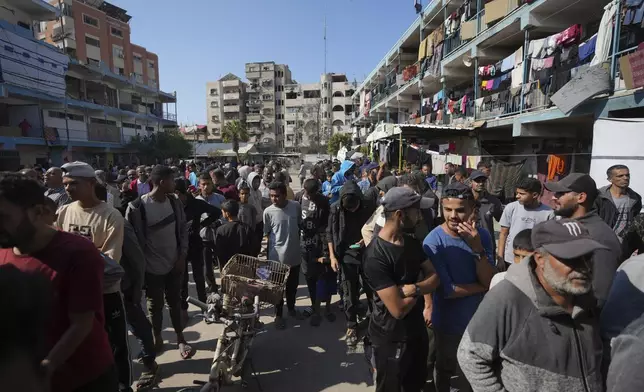 Palestinians gather to receive aid distributed by UNRWA, the U.N. agency helping Palestinian refugees, in Nusairat refugee camp, Gaza, Tuesday, Nov. 5, 2024. (AP Photo/Abdel Kareem Hana)