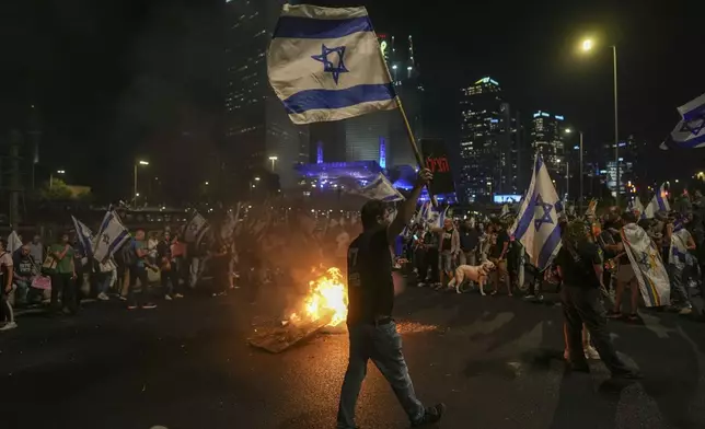 Israelis light a bonfire during a protest after Prime Minister Benjamin Netanyahu has dismissed his popular defense minister, Yoav Gallant, in a surprise announcement in Tel Aviv, Israel, Tuesday, Nov. 5, 2024. (AP Photo/Oded Balilty)