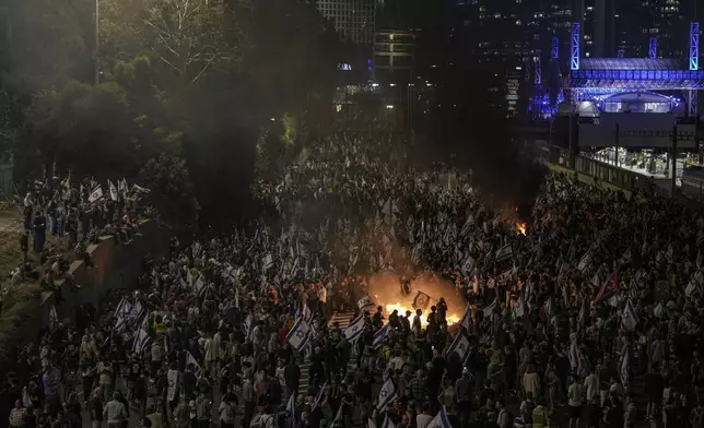 Israelis light a bonfire during a protest after Prime Minister Benjamin Netanyahu has dismissed his popular defense minister Yoav Gallant, in Tel Aviv, Israel, Tuesday, Nov. 5, 2024. (AP Photo/Oded Balilty)