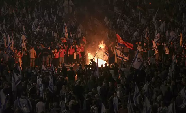 Israelis light a bonfire during a protest after Prime Minister Benjamin Netanyahu has dismissed his popular defense minister Yoav Gallant, in Tel Aviv, Israel, Tuesday, Nov. 5, 2024. (AP Photo/Oded Balilty)