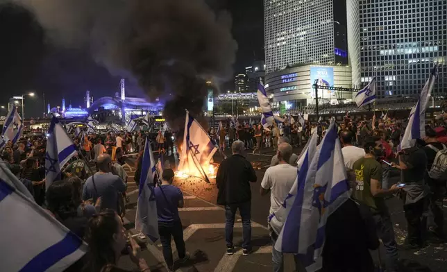 Israelis light a bonfire during a protest after Prime Minister Benjamin Netanyahu has dismissed his popular defense minister Yoav Gallant, in Tel Aviv, Israel, Tuesday, Nov. 5, 2024. (AP Photo/Oded Balilty)