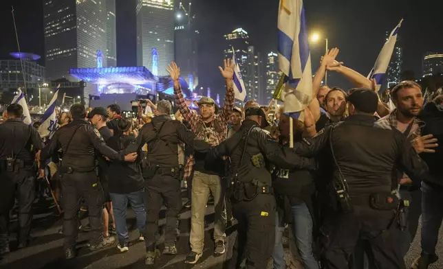 Israeli police try to push back protesters from a main road after Prime Minister Benjamin Netanyahu has dismissed his defense minister Yoav Gallant in a surprise announcement in Tel Aviv, Israel, Tuesday, Nov. 5, 2024. (AP Photo/Oded Balilty)