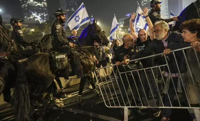 Israeli police try to push back protesters from a main road after Prime Minister Benjamin Netanyahu has dismissed his defense minister Yoav Gallant in a surprise announcement in Tel Aviv, Israel, Tuesday, Nov. 5, 2024. (AP Photo/Oded Balilty)