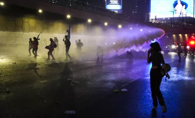 Police use water cannon to clear a group of people during a protest after Prime Minister Benjamin Netanyahu has dismissed his defense minister Yoav Gallant in a surprise announcement in Tel Aviv, Israel, early Wednesday, Nov. 6, 2024. (AP Photo/Francisco Seco)