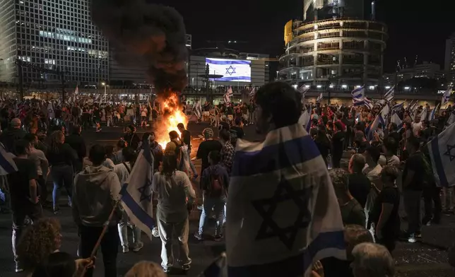 Israelis light a bonfire during a protest after Prime Minister Benjamin Netanyahu has dismissed his popular defense minister Yoav Gallant, in Tel Aviv, Israel, Tuesday, Nov. 5, 2024. (AP Photo/Oded Balilty)