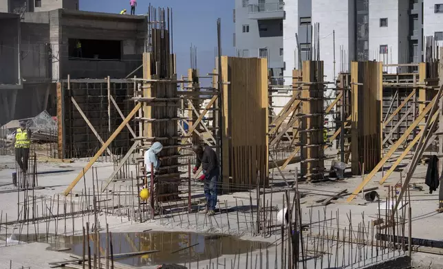 Palestinian laborers work at the site of a new housing project in the Jewish West Bank Jewish Settlement of Beit El, Monday, Nov. 11, 2024. (AP Photo/Ohad Zwigenberg)