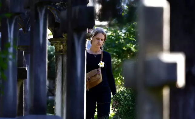 A woman walks in a cemetery on the occasion of All Saints Day, in Rome, Friday, Nov. 1, 2024. (Cecilia Fabiano/LaPresse via AP)