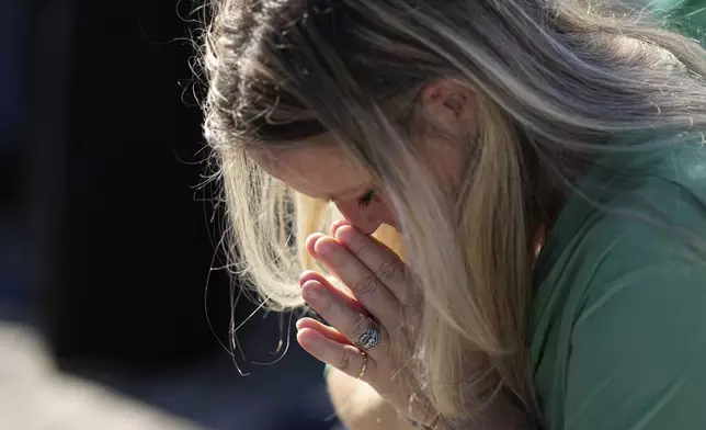 A woman prays during a mass with Pope Francis on the occasion of All Souls Day, at the Laurentino cemetery in the outskirts of Rome, Saturday, Nov. 2, 2024. (AP Photo/Andrew Medichini)