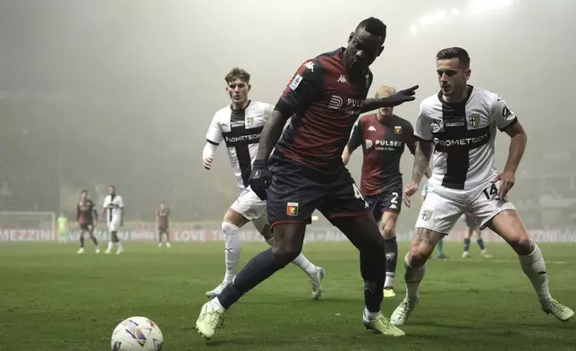 Genoa's Mario Balotelli, front, fights for the ball with Parma's Emanuele Valeri, right, during the Serie A soccer match between Parma and Genoa at Ennio Tardini Stadium in Parma, Italy, Monday, Nov. 4, 2024. (Massimo Paolone/LaPresse via AP)