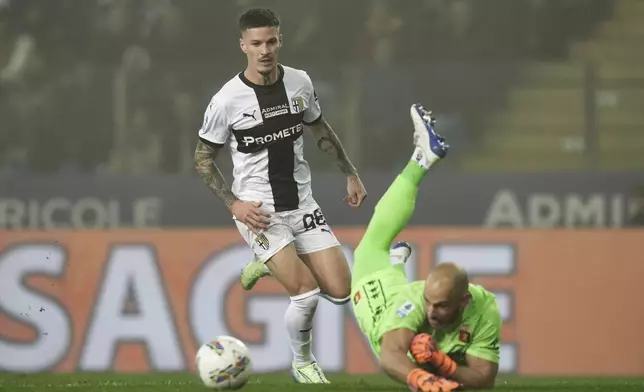 Parma's Dennis Man vies for the ball with Genoa's goalkeeper Nicola Leali during the Serie A match between Parma and Genoa at the Ennio Tardini Stadium in Parma, Italy, Monday Nov. 4, 2024. (Massimo Paolone/LaPresse via AP)