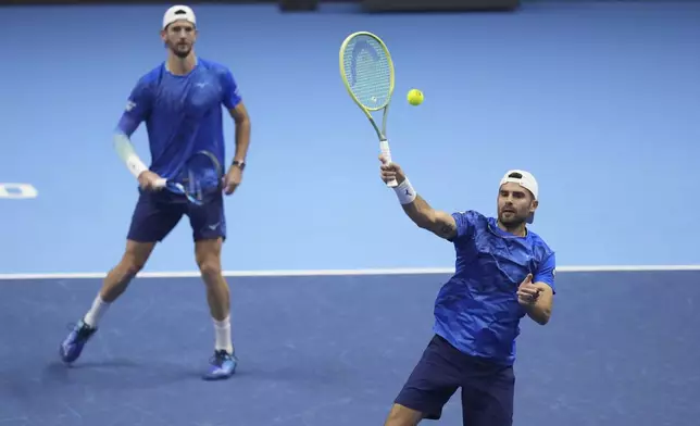 Italy's Simone Bolelli, right, and Andrea Vavassori return the ball to India's Rohan Bopanna and Australia's Matthew Ebden during their doubles tennis match of the ATP World Tour Finals at the Inalpi Arena, in Turin, Italy, Monday, Nov. 11, 2024. (AP Photo/Antonio Calanni)