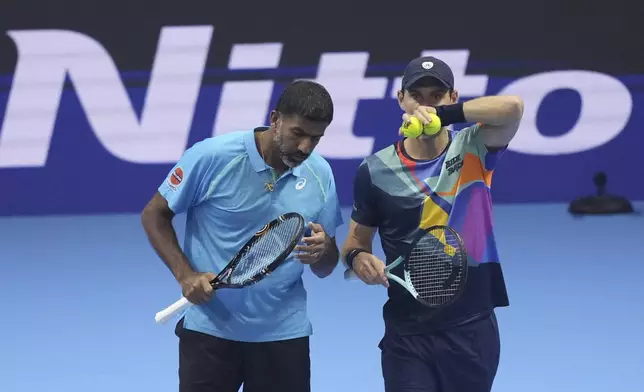 India's Rohan Bopanna, left, and Australia's Matthew Ebden talk during their doubles tennis match of the ATP World Tour Finals against Italy's Simone Bolelli and Andrea Vavassori, at the Inalpi Arena, in Turin, Italy, Monday, Nov. 11, 2024. (AP Photo/Antonio Calanni)