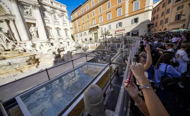 A small pool is seen in front of the Trevi Fountain to allow tourists to throw their coins in it, as the fountain has been emptied to undergo maintenance work that will last until around September 2025, in Rome, Friday, Nov. 1, 2024. (AP Photo/Andrew Medichini)