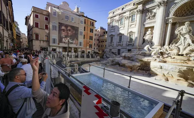 A small pool is seen in front of the Trevi Fountain to allow tourists to throw their coins in it, as the fountain has been emptied to undergo maintenance work that will last until around September 2025, in Rome, Friday, Nov. 1, 2024. (AP Photo/Andrew Medichini)