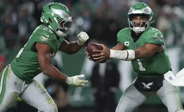 Philadelphia Eagles quarterback Jalen Hurts (1) hands off to Eagles running back Saquon Barkley (26) during the second half of an NFL football game against the Jacksonville Jaguars on Sunday, Nov. 3, 2024, in Philadelphia. (AP Photo/Matt Slocum)