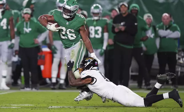 Philadelphia Eagles running back Saquon Barkley (26) runs with the ball while Jacksonville Jaguars safety Andre Cisco (5) tackles him during the second half of an NFL football game Sunday, Nov. 3, 2024, in Philadelphia. (AP Photo/Chris Szagola)