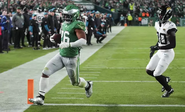 Philadelphia Eagles running back Saquon Barkley (26) scores a touchdown in front of Jacksonville Jaguars cornerback Montaric Brown (30) during the first half of an NFL football game Sunday, Nov. 3, 2024, in Philadelphia. (AP Photo/Chris Szagola)