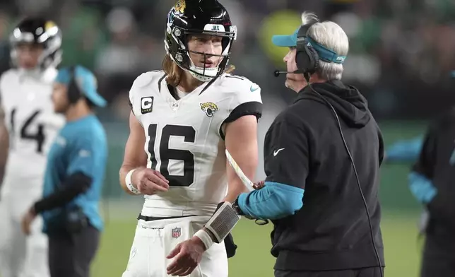 Jacksonville Jaguars quarterback Trevor Lawrence (16) talks to Jaguars head coach Doug Pederson during the second half of an NFL football game against the Philadelphia Eagles on Sunday, Nov. 3, 2024, in Philadelphia. (AP Photo/Chris Szagola)