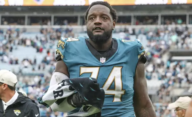 FILE -Jacksonville Jaguars offensive tackle Cam Robinson (74) leaves the field after an NFL football game against the Indianapolis Colts, Sunday, Oct. 6, 2024, in Jacksonville, Fla. (AP Photo/Gary McCullough, File)