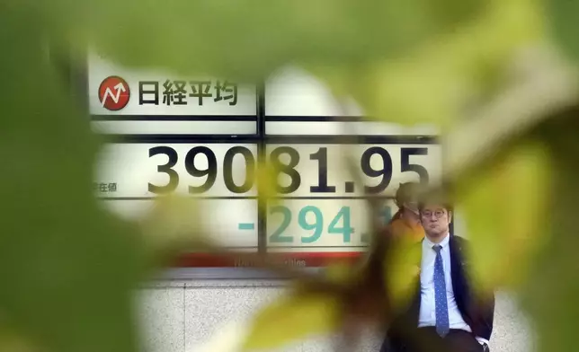 A person stands in front of an electronic stock board showing Japan's Nikkei index at a securities firm Wednesday, Nov. 13, 2024, in Tokyo. (AP Photo/Eugene Hoshiko)