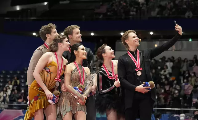 Silver medalists Christina Carreira and Anthony Ponomarenko of the U.S., left, gold medalists Madison Chock and Evan Bates of the U.S., center, and bronze medalists Allison Reed and Saulius Ambrulevicius of Lithuania pose for a selfie after competing the ice dance segment at the Grand Prix of Figure Skating series competition in Tokyo, Saturday, Nov. 9, 2024. (AP Photo/Hiro Komae)