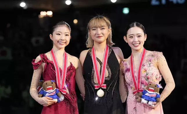 Silver medalist Mone Chiba of Japan, left, gold medalist Kaori Sakamoto of Japan, center, and bronze medalist Yuna Aoki of Japan pose for a photo after competing the women's free skating at the Grand Prix of Figure Skating series competition in Tokyo, Saturday, Nov. 9, 2024. (AP Photo/Hiro Komae)