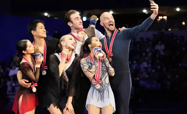 Silver medalists, Riku Miura and Ryuichi Kihara of Japan, left, gold medalists, Anastasiia Metelkina and Luka Berulava of Georgia, center, and bronze medalists Ellie Kam and Danny O'Shea of the U.S., right, pose for a selfie after competing the pairs' free skating at the Grand Prix of Figure Skating series competition in Tokyo, Saturday, Nov. 9, 2024. (AP Photo/Hiro Komae)