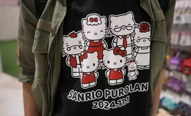 A Hello Kitty fan shows off his t-shirt showing Kitty's family members while visiting Sanrio Puroland to celebrate its best known character's 50th birth anniversary, in Tama, a western suburb of Tokyo, Japan, Friday, Nov. 1, 2024. (AP Photo/Hiro Komae)