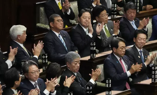 Lawmakers applaud as Japanese Prime Minister Shigeru Ishiba, second left on top, was elected for a new prime minister at a special parliamentary session of the lower house Monday, Nov. 11, 2024, in Tokyo. (AP Photo/Eugene Hoshiko)