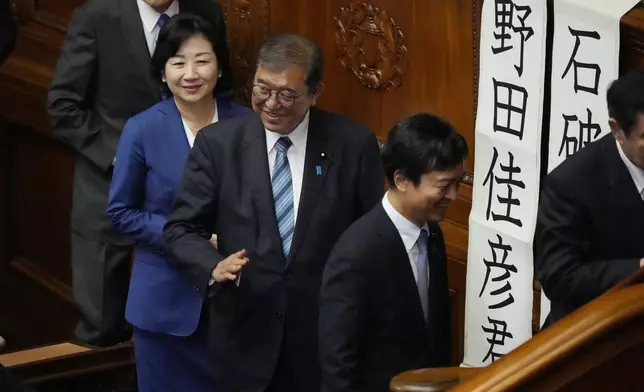 Japanese Prime Minister Shigeru Ishiba, center, queues for a runoff vote for a new prime minister at a special parliamentary session of the lower house Monday, Nov. 11, 2024, in Tokyo. (AP Photo/Eugene Hoshiko)