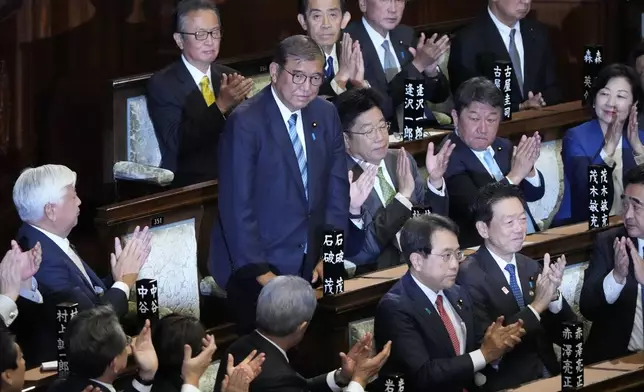 Lawmakers applaud as Japanese Prime Minister Shigeru Ishiba, standing, was elected for a new prime minister at a special parliamentary session of the lower house Monday, Nov. 11, 2024, in Tokyo. (AP Photo/Eugene Hoshiko)