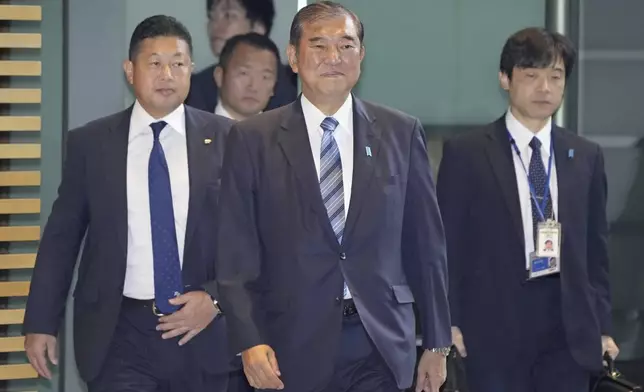 Japanese Prime Minister Shigeru Ishiba, center, arrives at his office in Tokyo Monday, Nov. 11, 2024. (Kyodo News via AP)