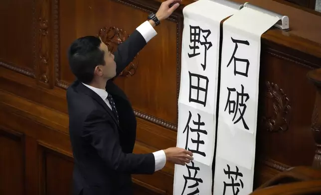 A staff member at parliament puts up two names, Shigeru Ishiba (of Japanese Prime Minister), right, and Yoshihiko Noda (leader of the Constitutional Democratic Party) for a runoff vote for a new prime minister at a special parliamentary session of the lower house Monday, Nov. 11, 2024, in Tokyo. (AP Photo/Eugene Hoshiko)