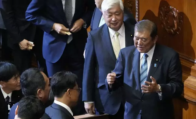 Japanese Prime Minister Shigeru Ishiba, right, speaks with other lawmakers at a special parliamentary session of the lower house Monday, Nov. 11, 2024, in Tokyo. (AP Photo/Eugene Hoshiko)