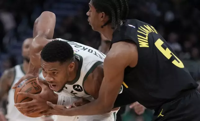 Milwaukee Bucks' Giannis Antetokounmpo gets past Utah Jazz's Cody Williams during the first half of an NBA basketball game Thursday, Nov. 7, 2024, in Milwaukee. (AP Photo/Morry Gash)