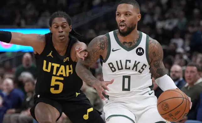 Utah Jazz's Taylor Hendricks gets past Utah Jazz's Cody Williams during the first half of an NBA basketball game Thursday, Nov. 7, 2024, in Milwaukee. (AP Photo/Morry Gash)