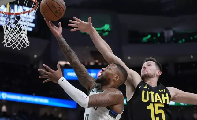 Milwaukee Bucks' Damian Lillard shoots past Utah Jazz's Drew Eubanks during the first half of an NBA basketball game Thursday, Nov. 7, 2024, in Milwaukee. (AP Photo/Morry Gash)