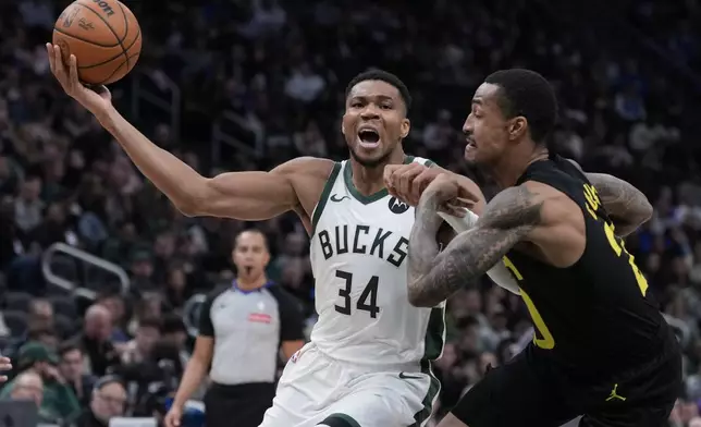 Milwaukee Bucks' Giannis Antetokounmpo tries to get past Utah Jazz's John Collins during the first half of an NBA basketball game Thursday, Nov. 7, 2024, in Milwaukee. (AP Photo/Morry Gash)