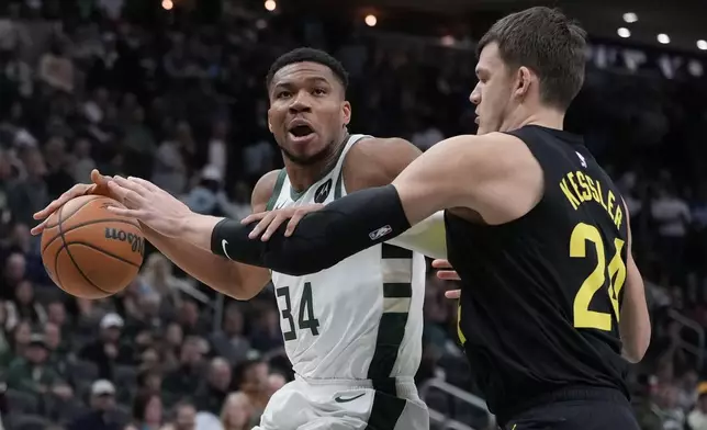 Milwaukee Bucks' Giannis Antetokounmpo tries to get past Utah Jazz's John Collins during the first half of an NBA basketball game Thursday, Nov. 7, 2024, in Milwaukee. (AP Photo/Morry Gash)