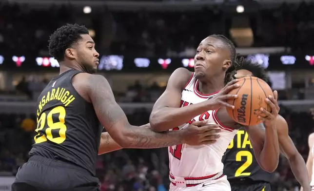 Chicago Bulls' Ayo Dosunmu, right, drives to the basket as Utah Jazz's Brice Sensabaugh defends during the first half of an NBA basketball game Monday, Nov. 4, 2024, in Chicago. (AP Photo/Charles Rex Arbogast)