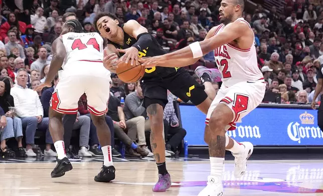 Utah Jazz's Keyonte George, left, drives to the basket as Chicago Bulls' Talen Horton-Tucker defends during the second half of an NBA basketball game Monday, Nov. 4, 2024, in Chicago. (AP Photo/Charles Rex Arbogast)