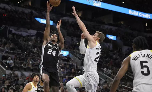 San Antonio Spurs' Devin Vassell (24) shoots against Utah Jazz's Lauri Markkanen during the first half of an NBA basketball game, Saturday, Nov. 9, 2024, in San Antonio. (AP Photo/Darren Abate)