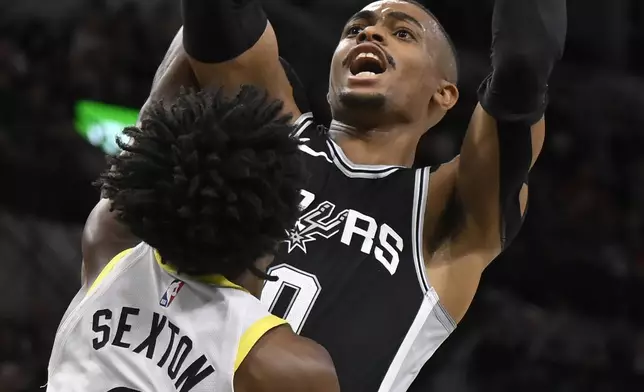 San Antonio Spurs' Keldon Johnson, top, attempts to shoot against Utah Jazz's Collin Sexton (2) during the first half of an NBA basketball game, Saturday, Nov. 9, 2024, in San Antonio. (AP Photo/Darren Abate)