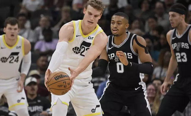 Utah Jazz's Lauri Markkanen, center left, fights for possession as he is defended by San Antonio Spurs' Keldon Johnson (0) during the first half of an NBA basketball game, Saturday, Nov. 9, 2024, in San Antonio. (AP Photo/Darren Abate)