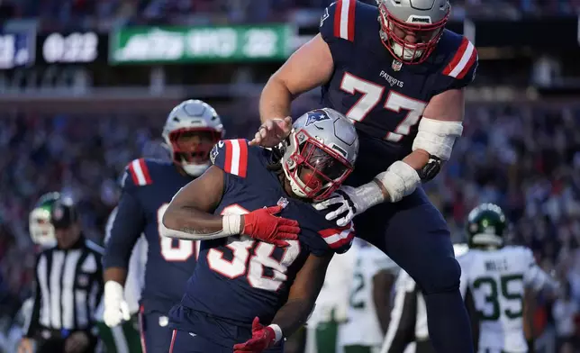 New England Patriots running back Rhamondre Stevenson (38) celebrates after his touchdown with center Ben Brown (77) in the second half of an NFL football game against the New York Jets, Sunday, Oct. 27, 2024, in Foxborough, Mass. (AP Photo/Charles Krupa)