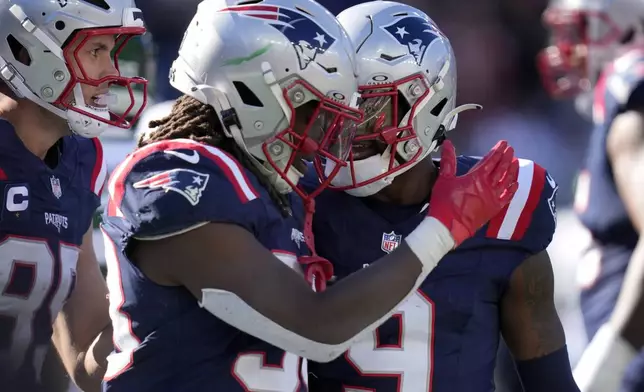 New England Patriots running back Rhamondre Stevenson, center left, celebrates his touchdown with wide receiver Kayshon Boutte, right, in the second half of an NFL football game, Sunday, Oct. 27, 2024, in Foxborough, Mass. (AP Photo/Charles Krupa)