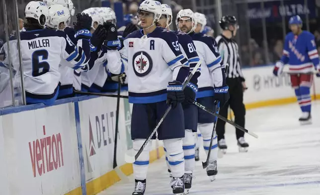 Winnipeg Jets' Mark Scheifele (55), center, celebrates with teammates after scoring during the third period of an NHL hockey game against the New York RangersTuesday, Nov. 12, 2024, in New York. The Jets defeated the Rangers 6-3. (AP Photo/Seth Wenig)